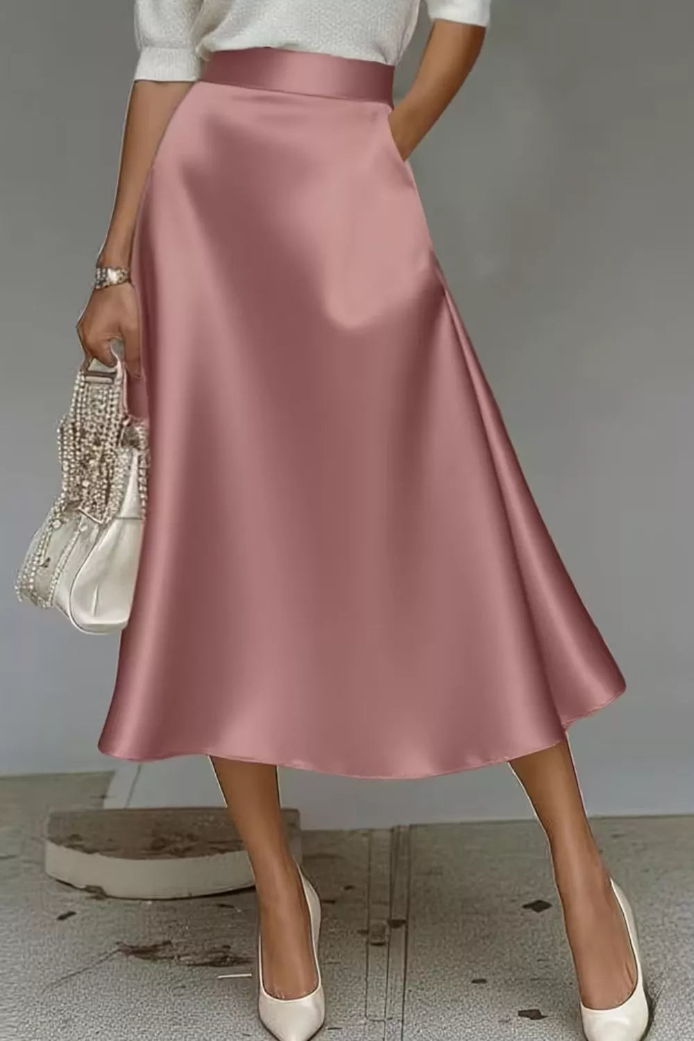 Person wearing a pink satin skirt with a plain background