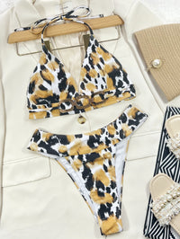 Leopard print bikini set on a hanger with accessories on a light background
