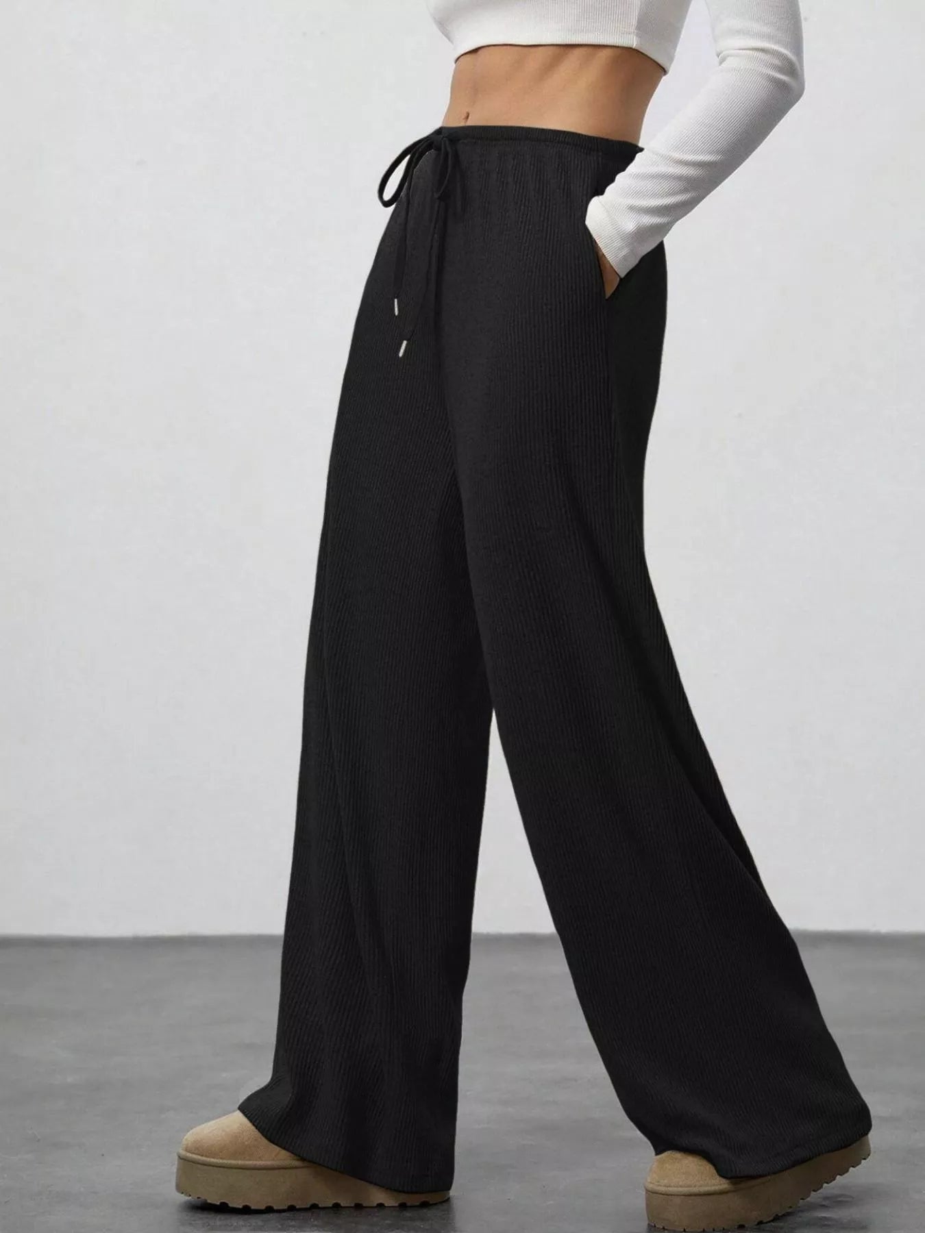 Black wide-leg pants worn by a person on a plain background