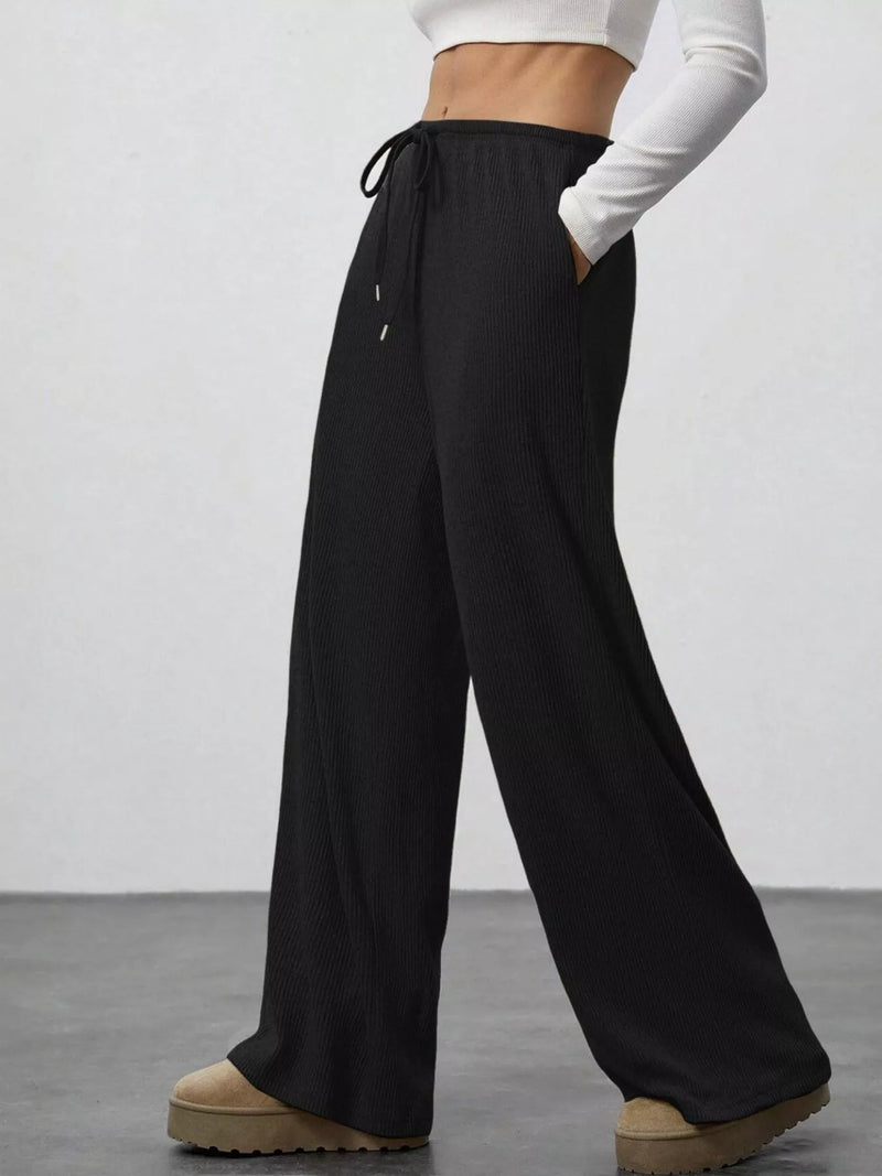 Black wide-leg pants worn by a person on a plain background