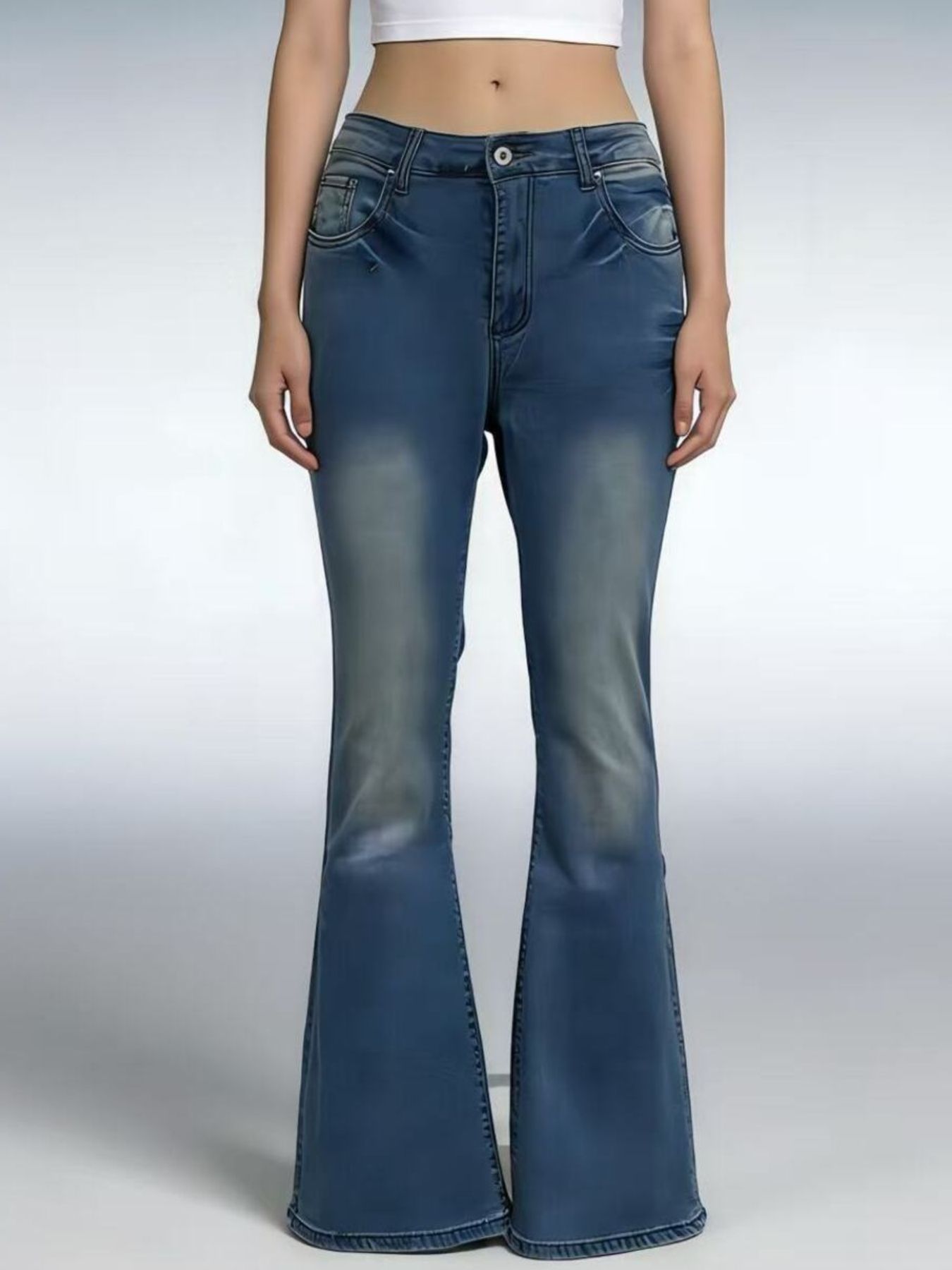 Blue flared jeans worn by a person on a gray background