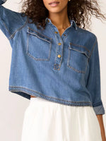 Person wearing a blue denim shirt with a white background