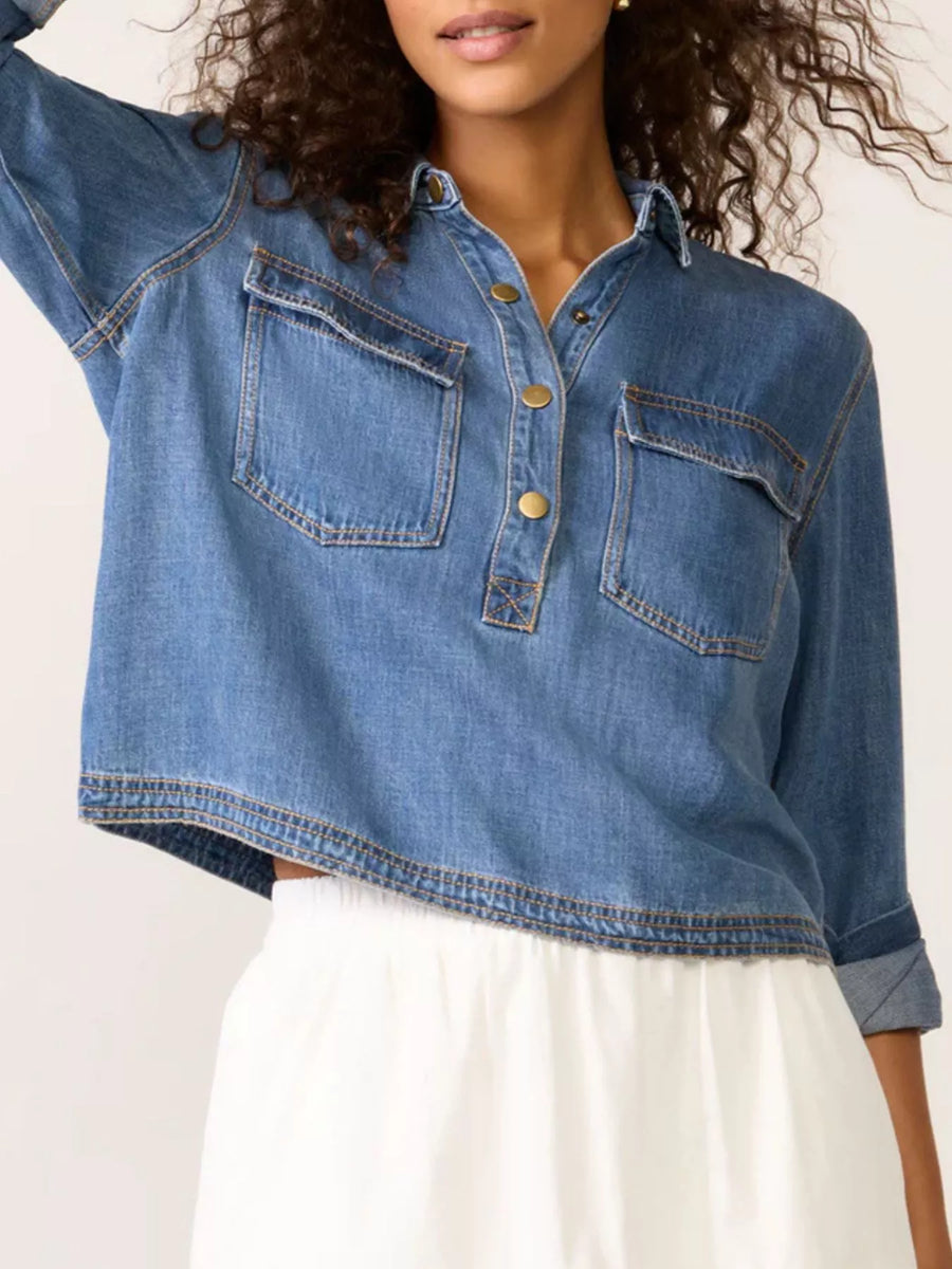 Person wearing a blue denim shirt with a white background