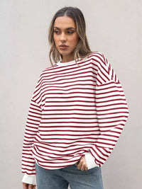 Woman wearing a red and white striped sweater against a plain background