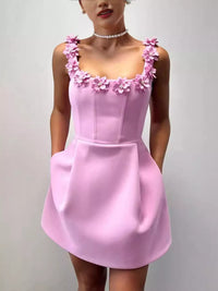 Pink dress with floral straps on a plain background