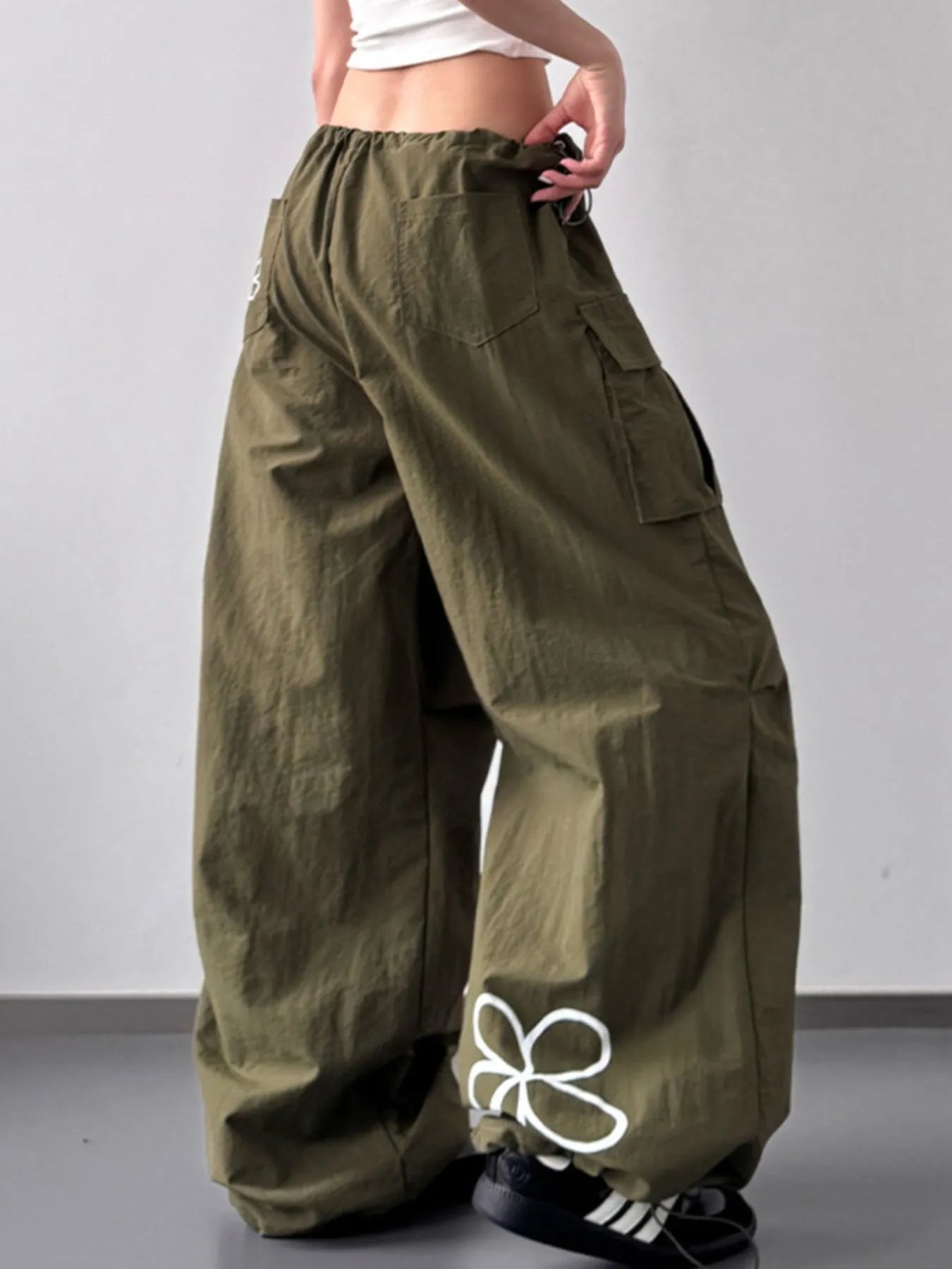 Person wearing olive green cargo pants on a plain background