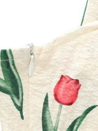 Close-up of a fabric with a red tulip design on a beige background