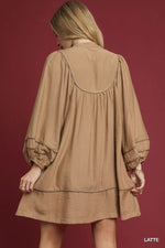 Woman wearing a beige dress with intricate detailing on a red background