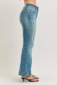Blue jeans worn by a person on a plain background