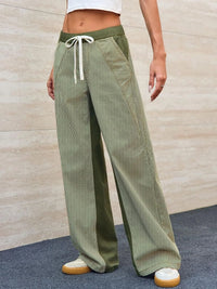 Person wearing green corduroy pants with a white background