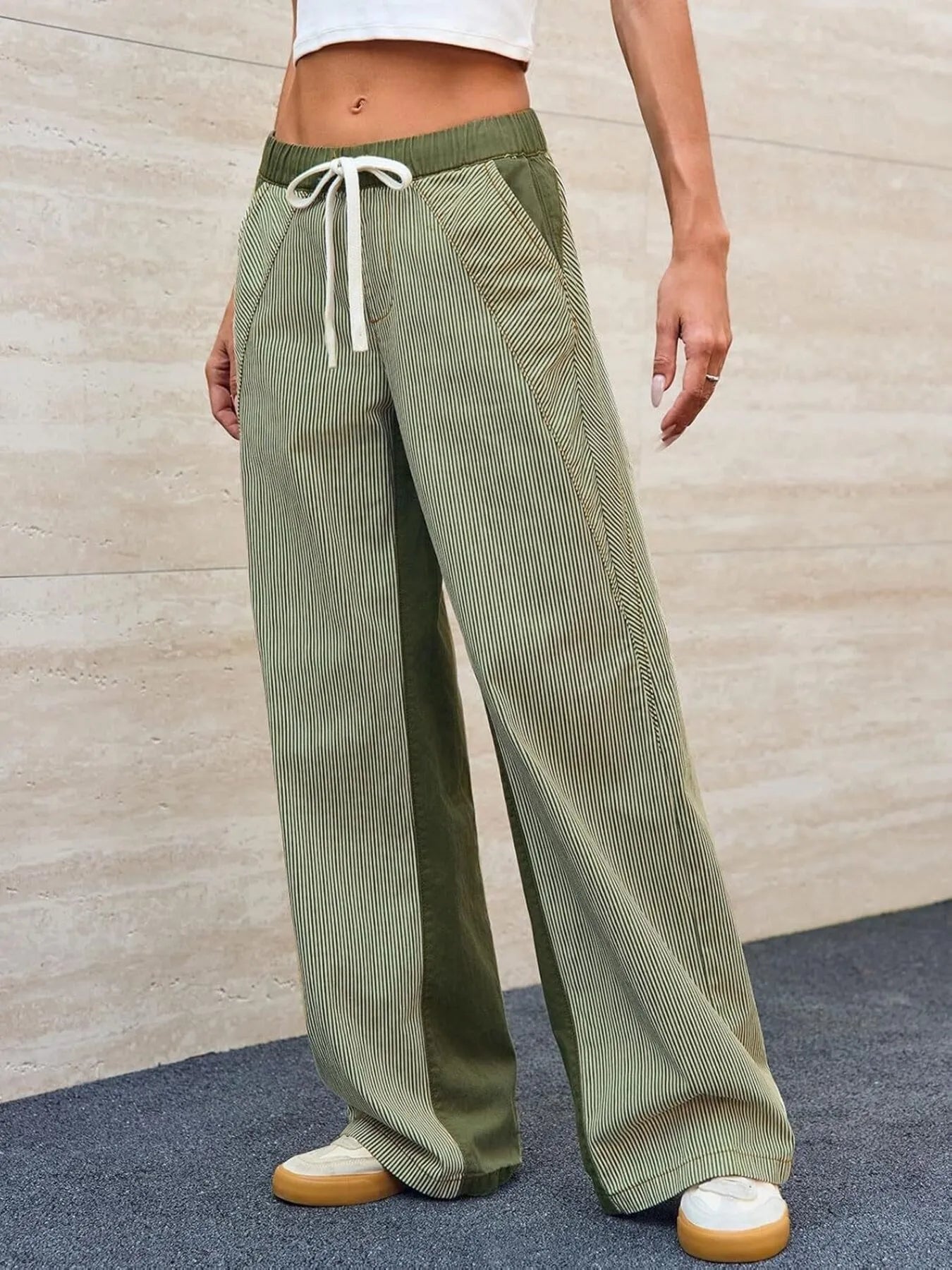 Person wearing green corduroy pants with a white background