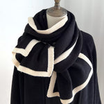 Black and white striped scarf on a mannequin against a plain background