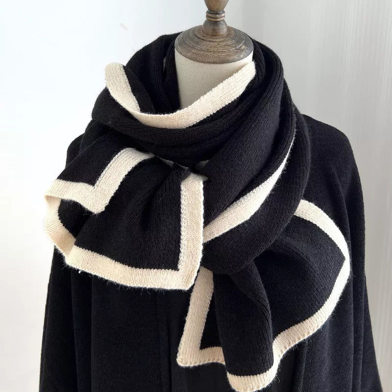 Black and white striped scarf on a mannequin against a plain background