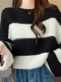 Person wearing a black and white striped sweater with a blurred background