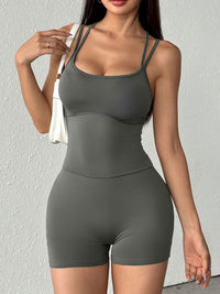Woman wearing a gray athletic outfit against a light gray background