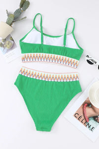 Green ribbed swimsuit with colorful trim on a white surface.