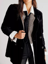 Person wearing a black coat with a white shirt and patterned scarf on a light gray background