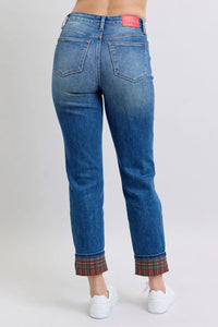 Blue jeans with plaid cuffs on a plain background
