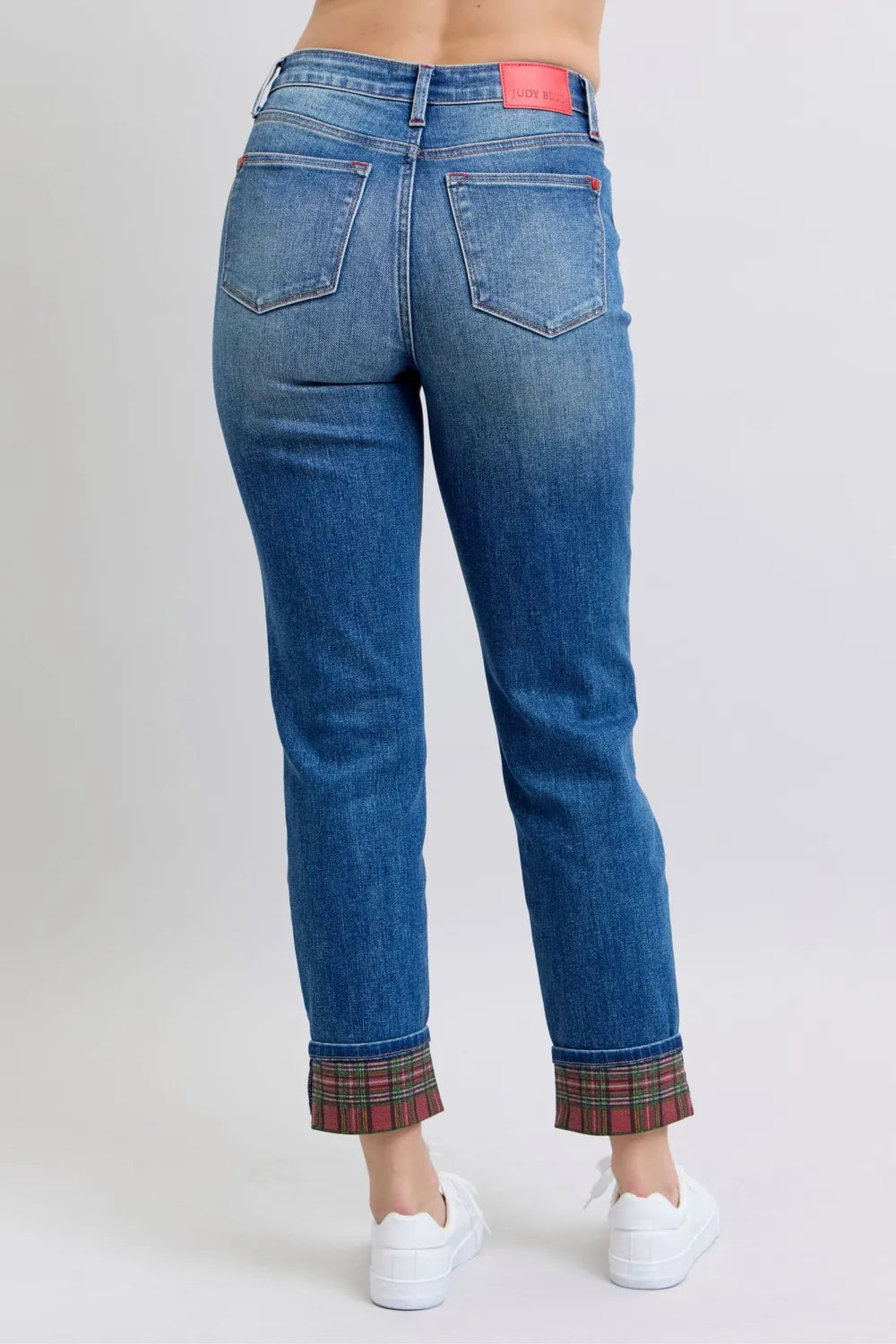 Blue jeans with plaid cuffs on a plain background