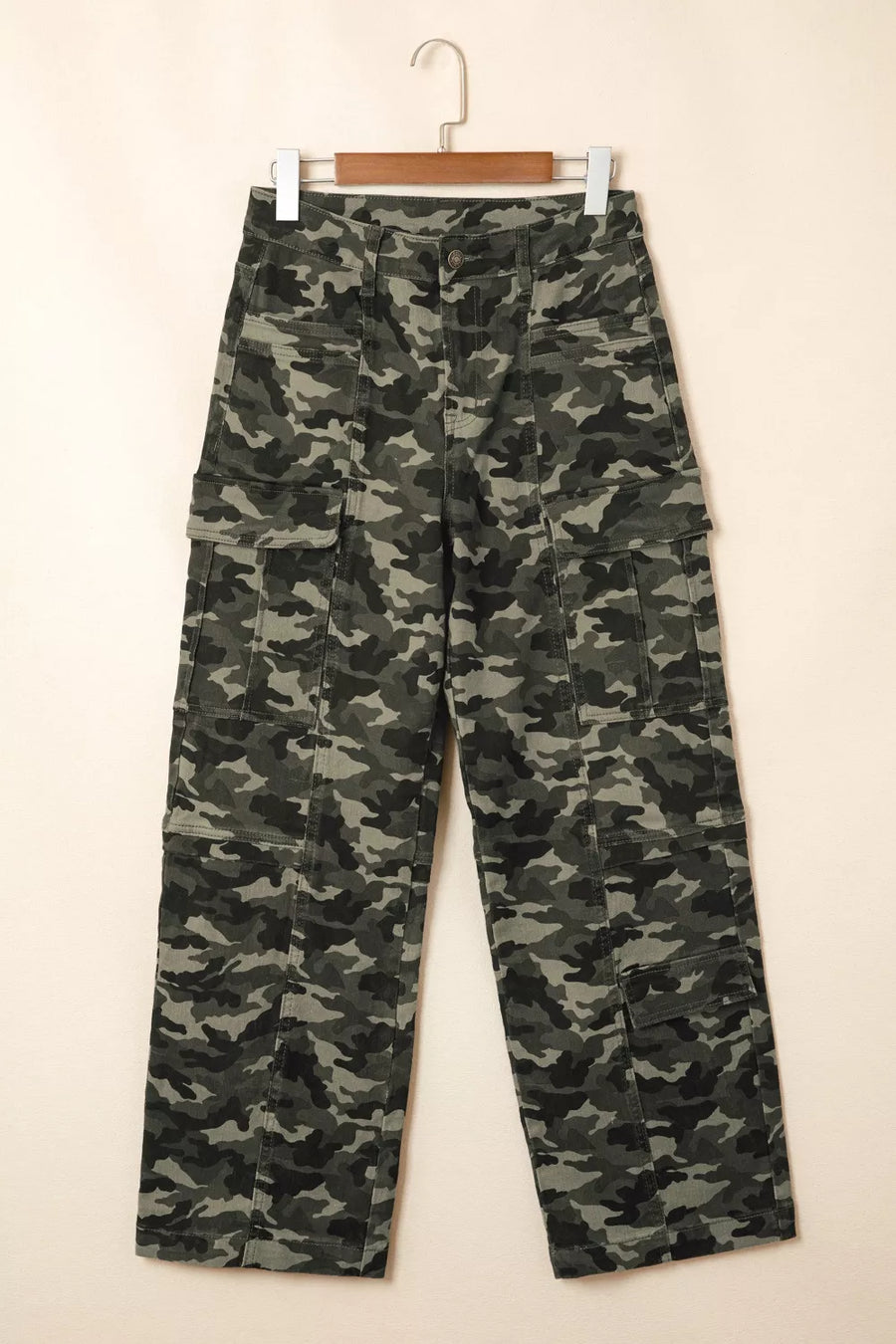 Camouflage pants on a hanger against a white background