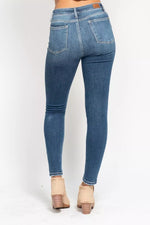 Blue jeans worn by a person on a white background