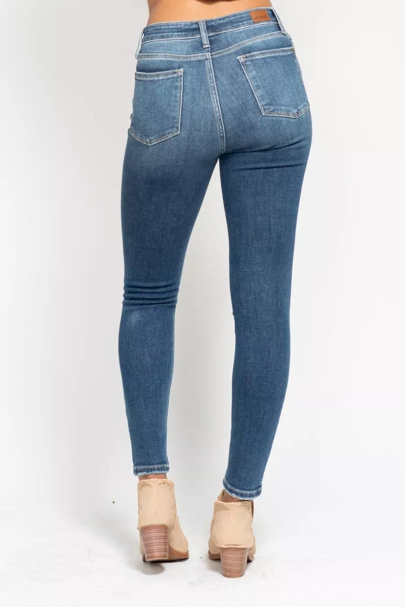 Blue jeans worn by a person on a white background