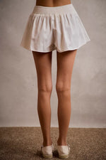 White shorts worn by a person on a neutral background