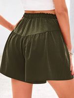 Green shorts worn by a person on a white background