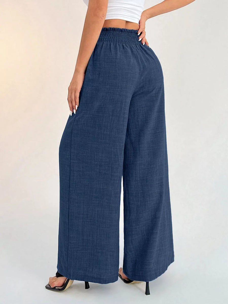 Person wearing blue wide-leg pants on a plain background