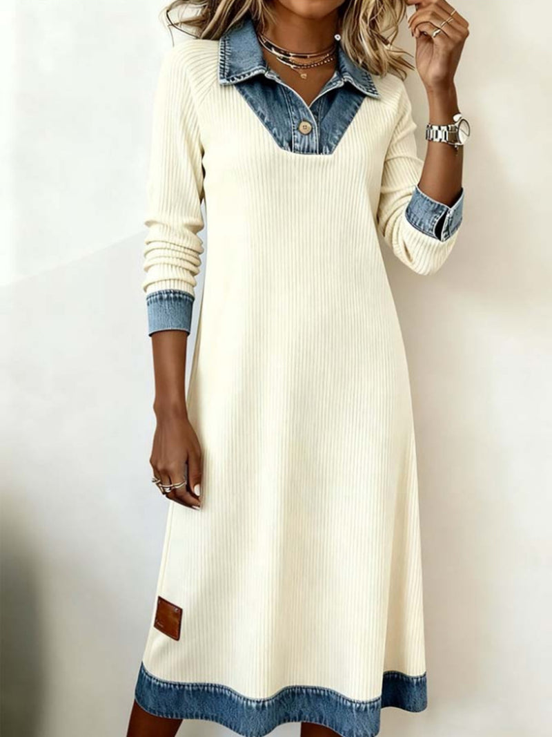 Woman wearing a cream-colored dress with denim accents on a plain background
