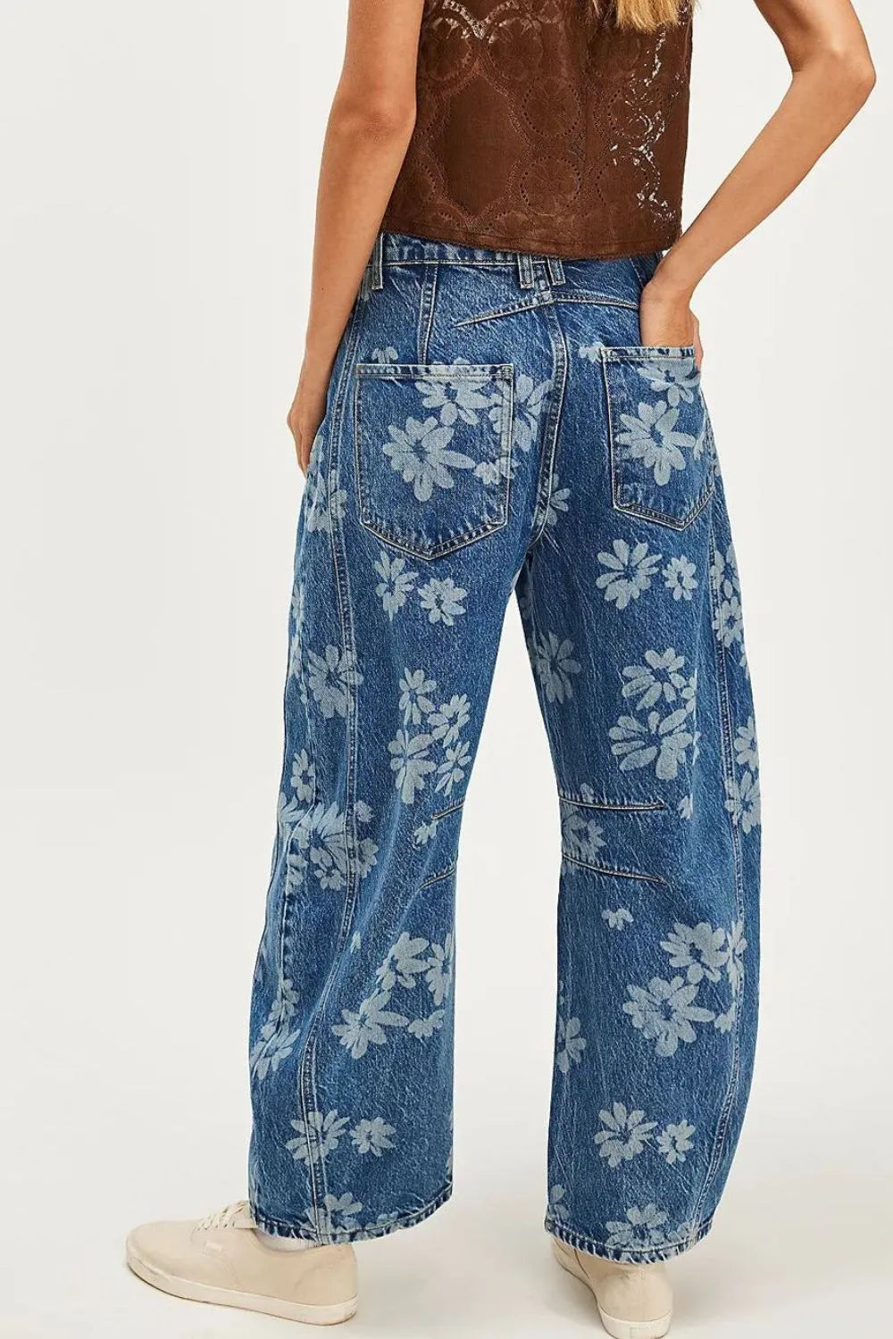 Blue floral-patterned jeans worn by a person on a white background