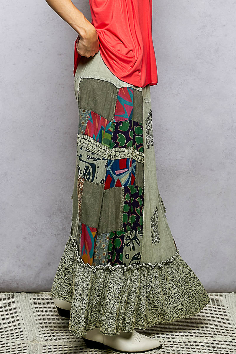 Person wearing a colorful patchwork skirt with a plain background