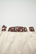 Beige skirt with a leopard print belt on a light gray background