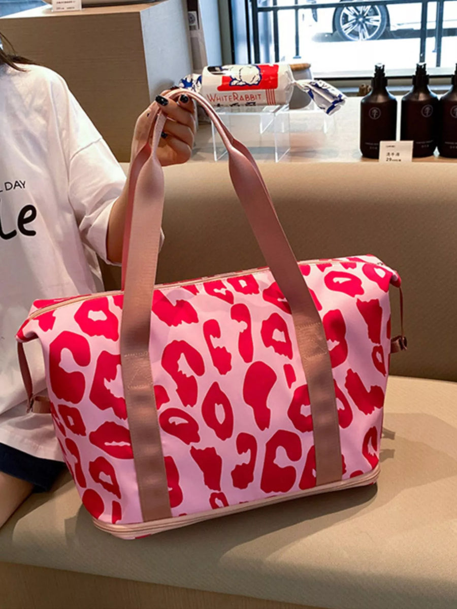 Person holding a pink duffel bag with red leopard print in an indoor setting