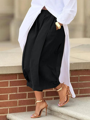 Person wearing a white shirt, black pants, and tan high-heeled shoes on a stone step.