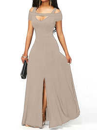 Woman wearing a long beige dress with cut-out shoulders on a white background