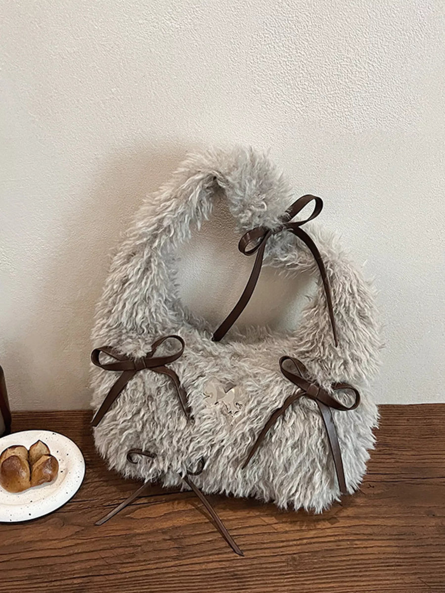 Fluffy white pet collar with brown bows on a wooden surface.