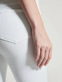 Close-up of a person wearing white jeans with a plain background