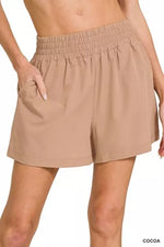 Beige shorts worn by a person on a white background