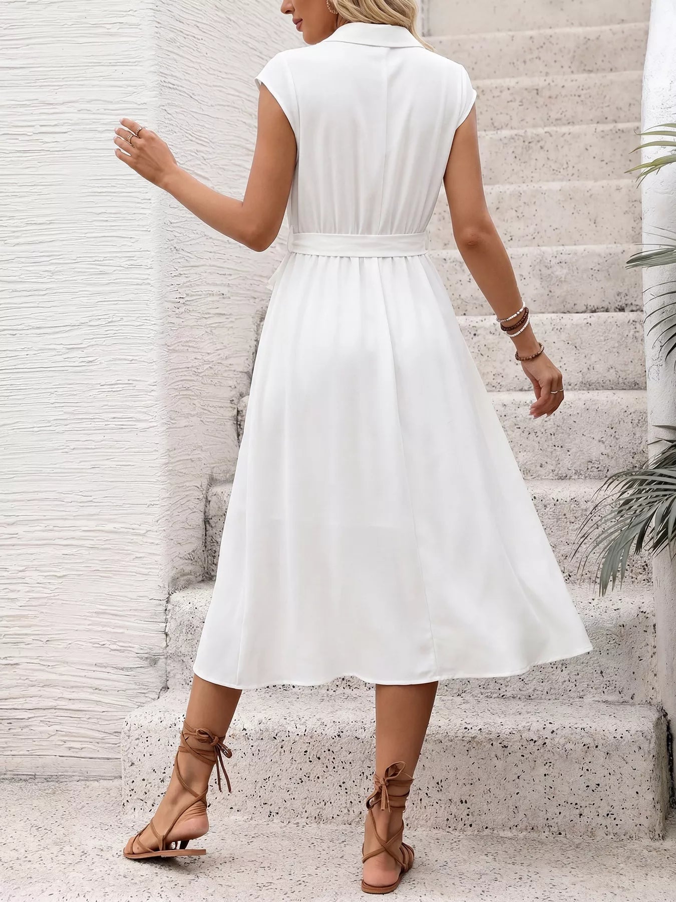 Woman wearing a white dress on a light background