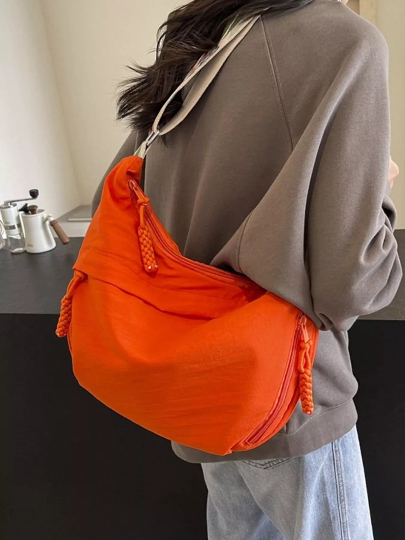 Person wearing an orange bag over one shoulder in a kitchen setting