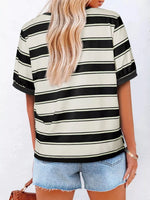 Person wearing a black and white striped shirt with denim shorts on a white background