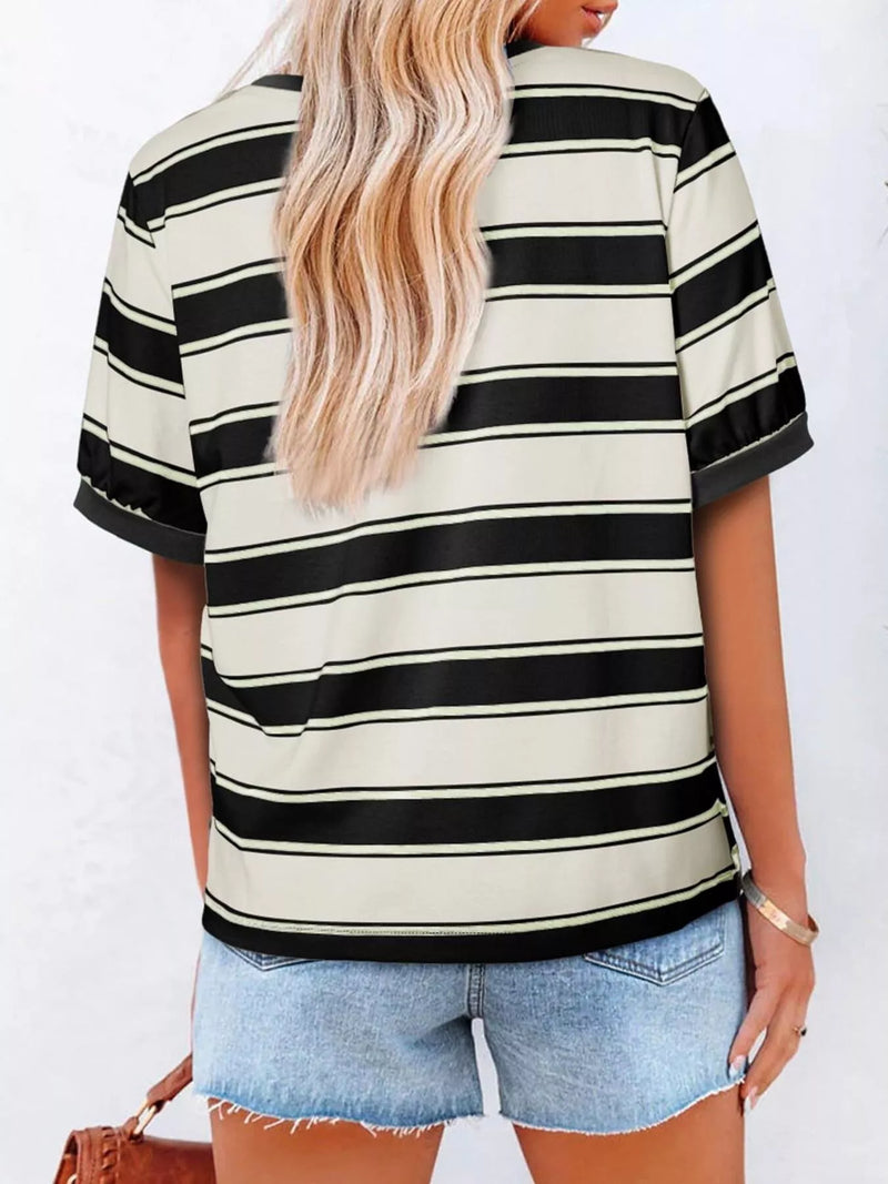 Person wearing a black and white striped shirt with denim shorts on a white background