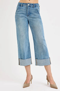 Blue jeans with rolled-up cuffs on a white background