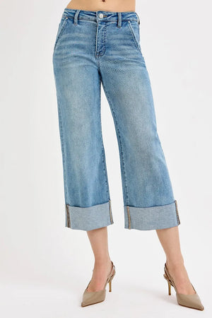 Blue jeans with rolled-up cuffs on a white background