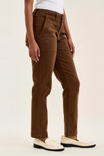 Brown pants worn by a person on a white background