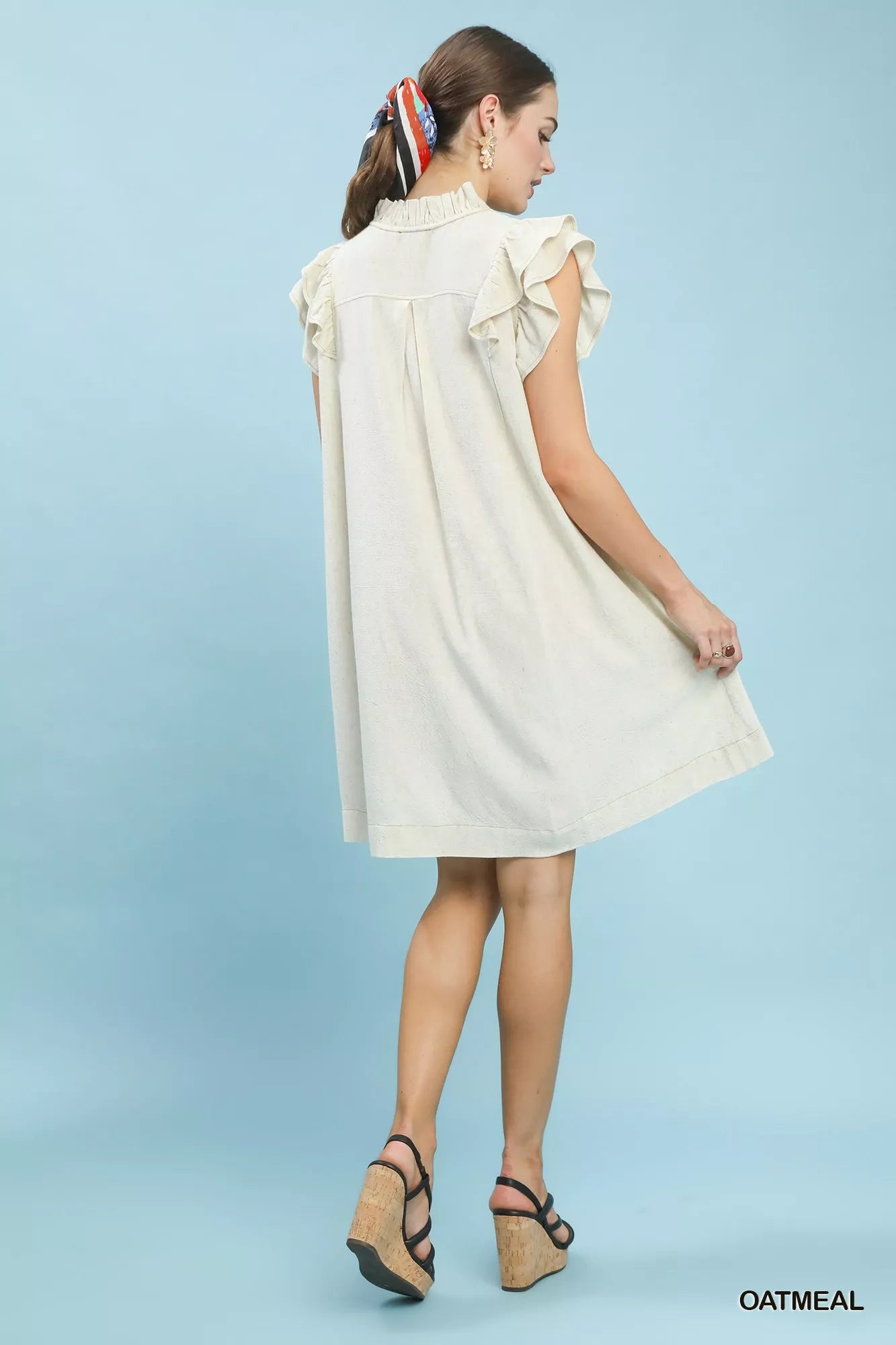 Woman wearing a white dress against a light blue background