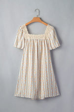 Floral dress on a hanger against a gray background