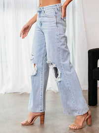 Light blue distressed jeans worn by a person in a minimal indoor setting.