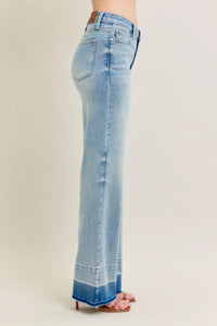 Light blue flared jeans on a beige background